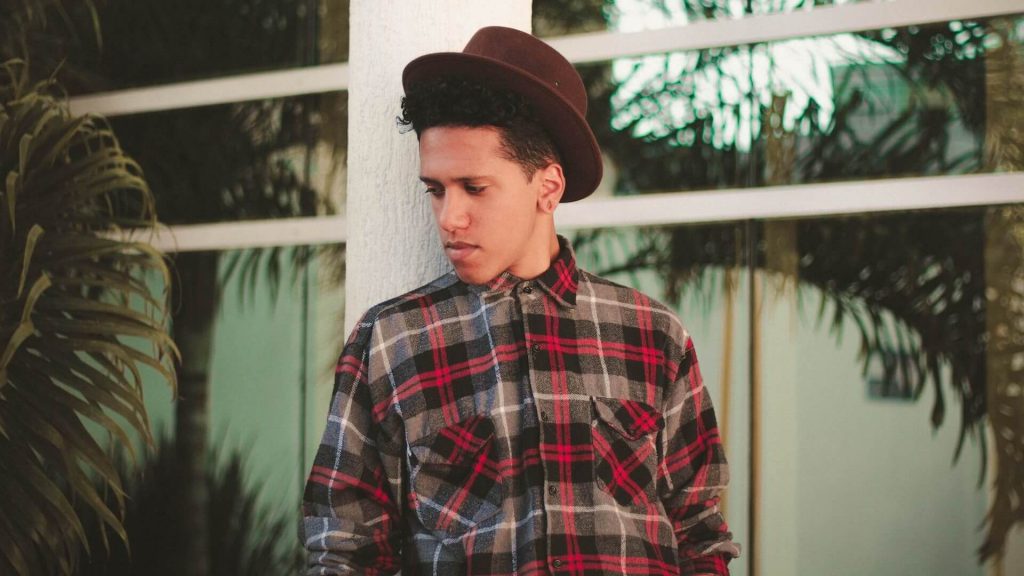 A hipster wearing a flannel and a fedora