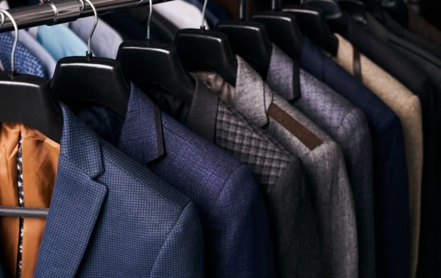 A rack with several suits, displaying a variety of styles and colors.