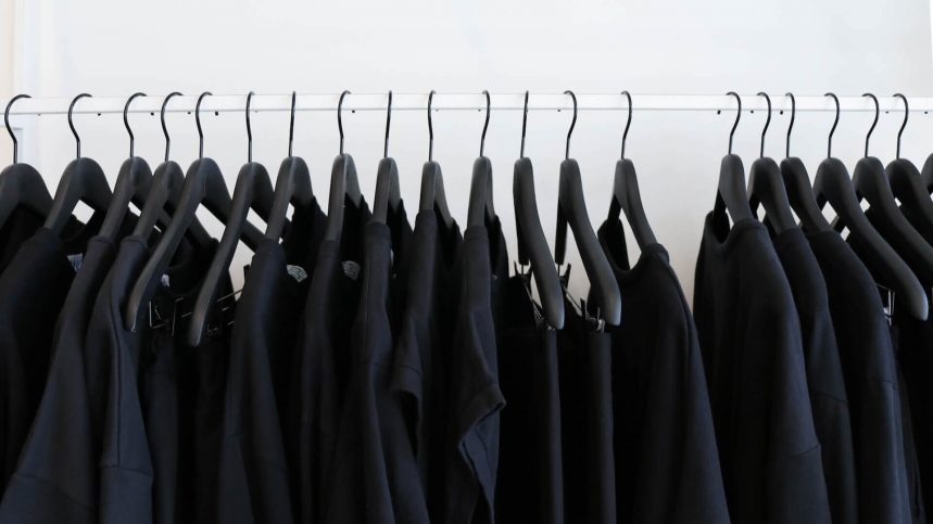 A clothes rack filled with black shirts